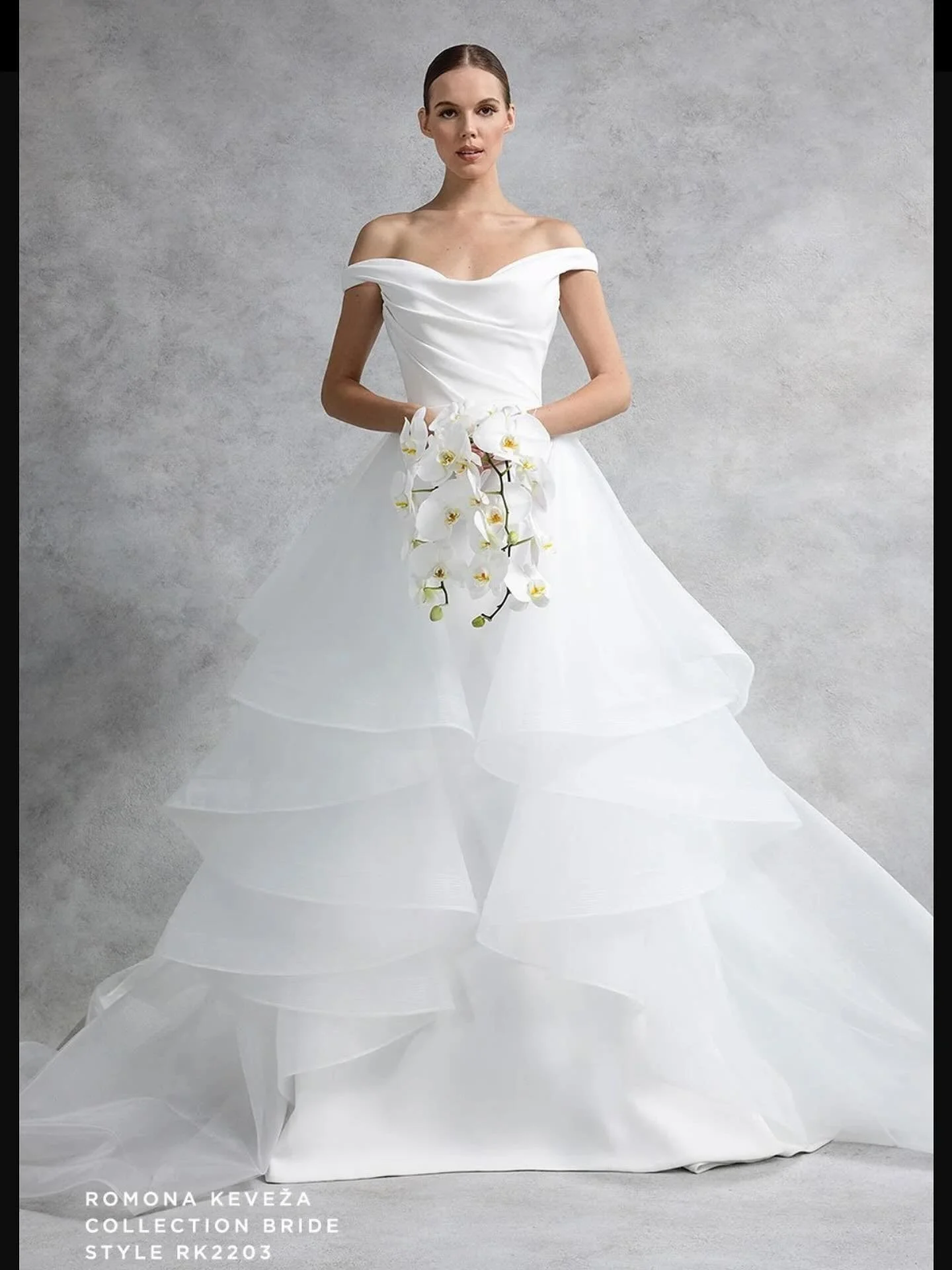 ROMONA&rsquo;S FAMOUS TWO IN ONE LOOKS. This time she pairs a softly sculpted off the shoulder bodice with a cascading ballgown skirt that is removable for the reception, revealing a completely different look with  a curvy fit and flare skirt. Perfec