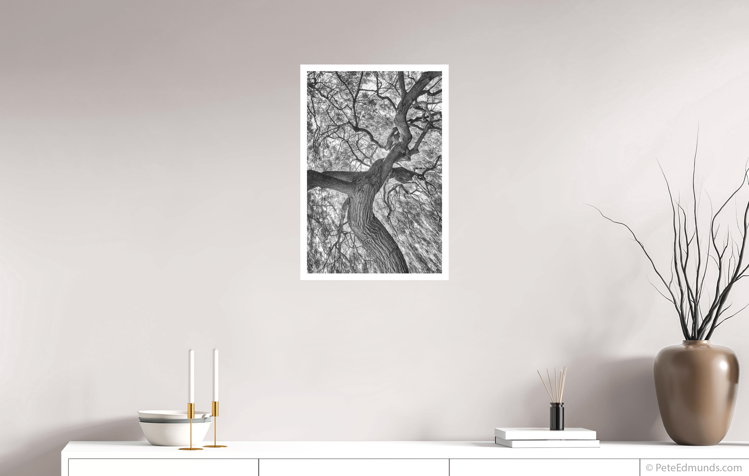 Fine art black and white print Tree of Life – Willow by Pete Edmunds, 60 × 40 cm with 2 cm white border, shown above a white sideboard in a modern interior.