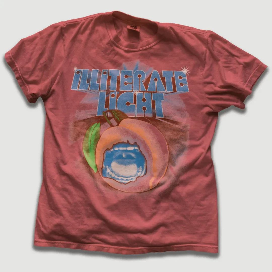 Peach T-shirt with Illiterate Light graphic print.