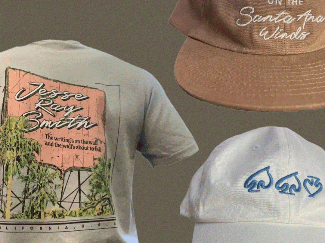 Display of apparel items including a white T-shirt with a Jessie Ray Smith graphic, a brown cap with white text, and a white cap with blue embroidery.