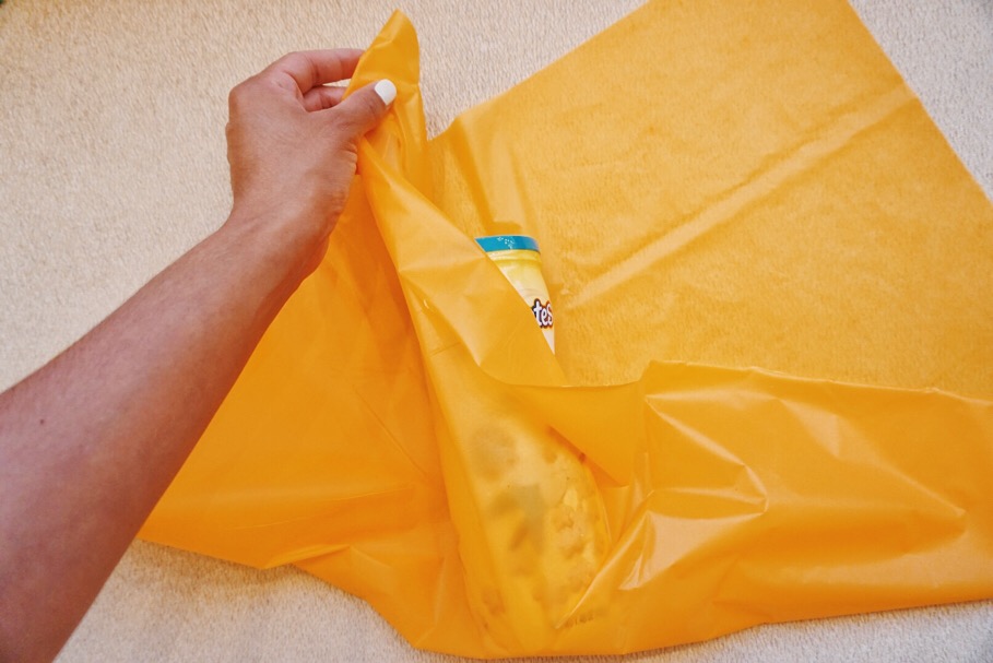 Place the snack container in the middle and start pulling the plastic up. 