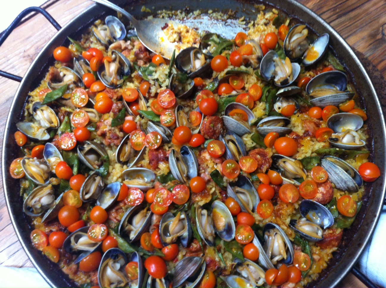 Large skillet dish with clams and cherry tomatoes