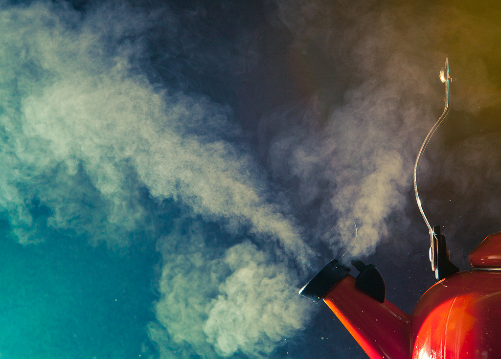 Image of a red tea kettle blowing clouds of steam - Creative Commons image by Benjamin Lehman 