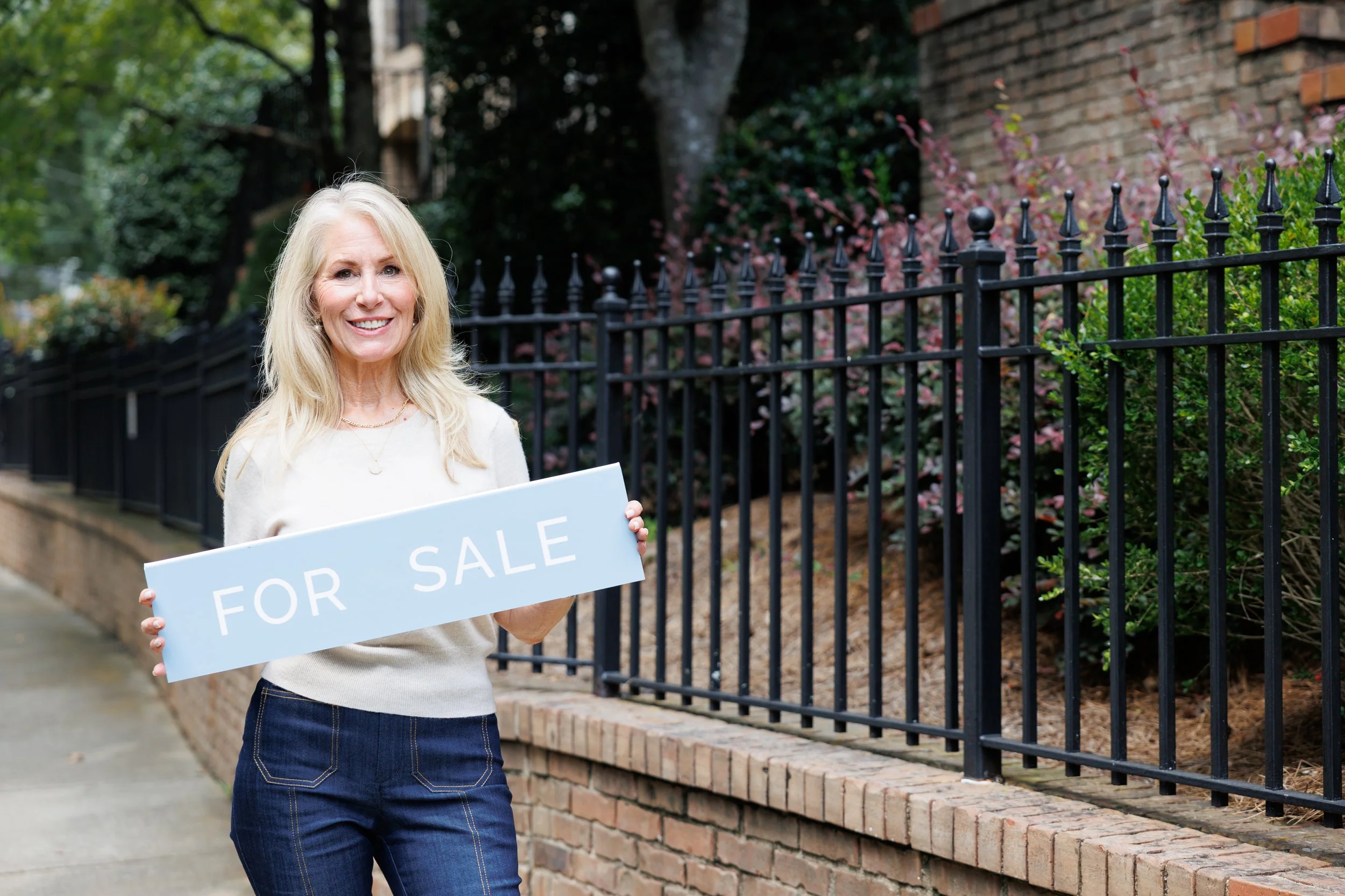 Realtor Shannon Inhouse holding a for sale sign, photography by CatMax Photography.