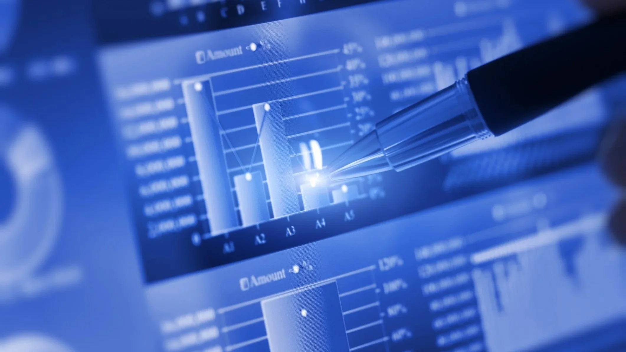 Close-up of a digital screen displaying financial or stock market data with a pen pointing to a specific bar graph.