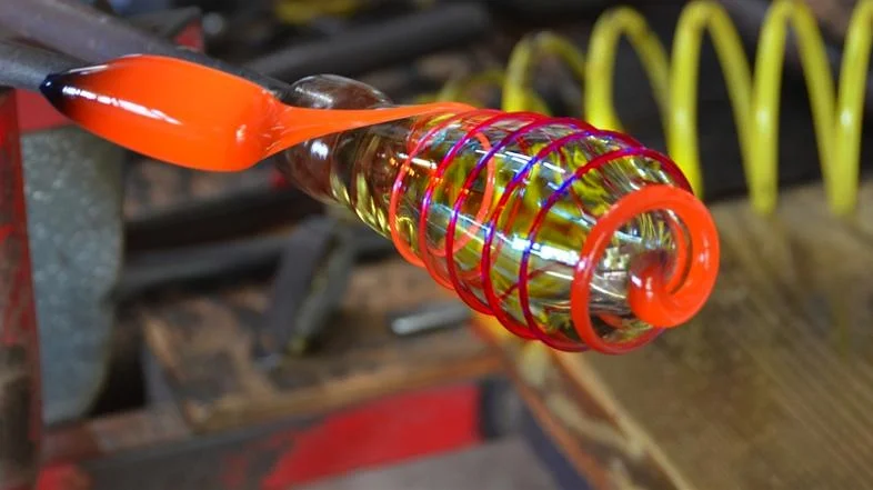 Threading hot glass to the piece in making a cup.