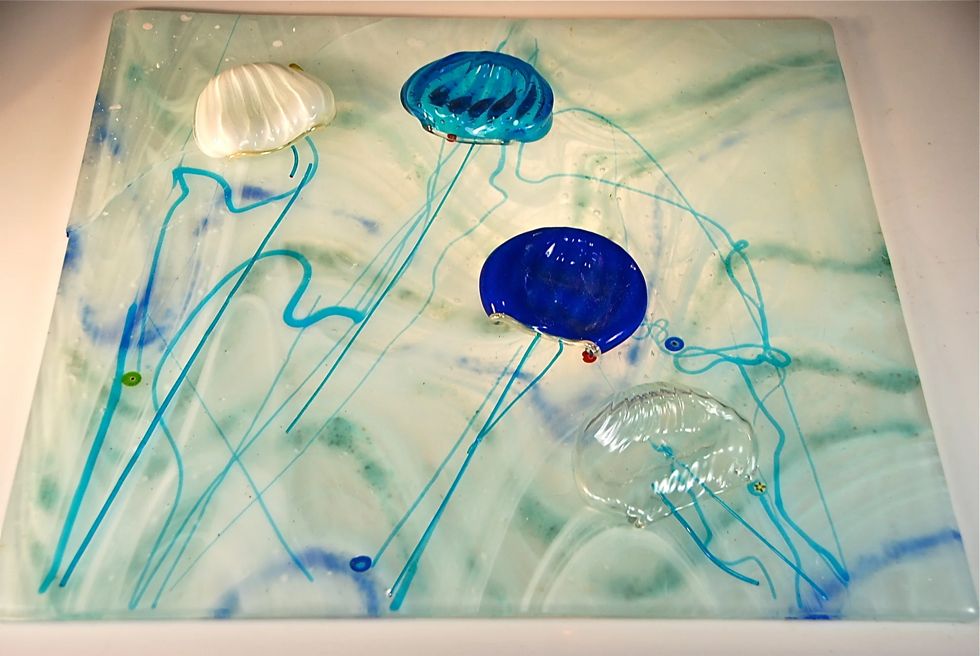 Fused Glass panel , then tack fused and slumped just a little to get the jellyfish to loose some shape and look real. 2015 prototype