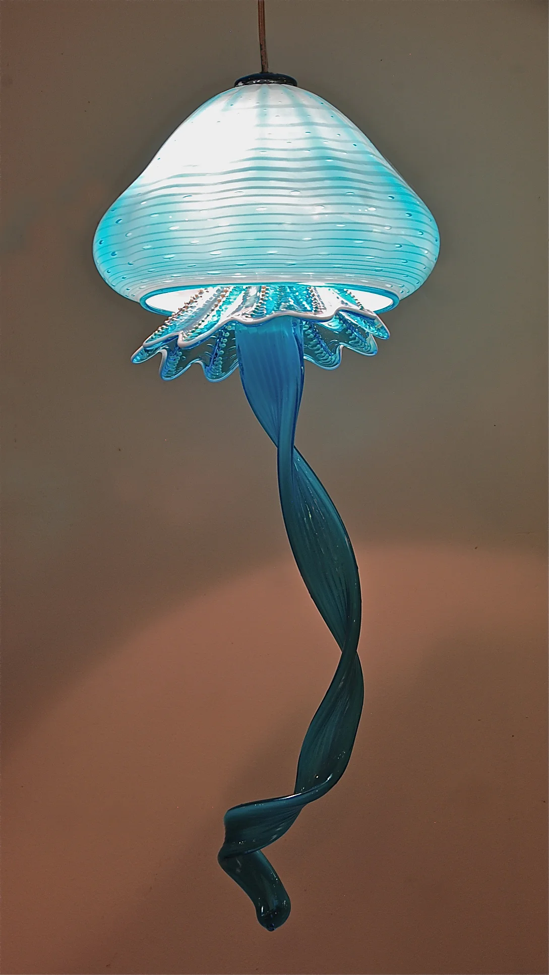 Turquoise Jelly Fish with optic patter and silver pearls apron and three tentacles. 11" x 27" 110v. LEDs signed and dated by the artist Rick Strini 2015