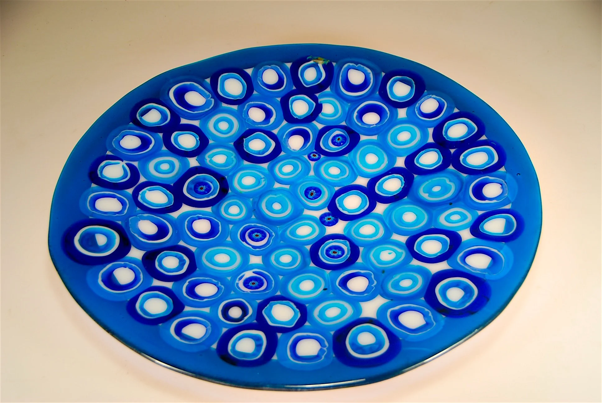 Blown Bars of "opihi" then cut on the saw and laid out to fuse. Slumped into shapes and blown feet added. 17" diameter. artist rick strini2015