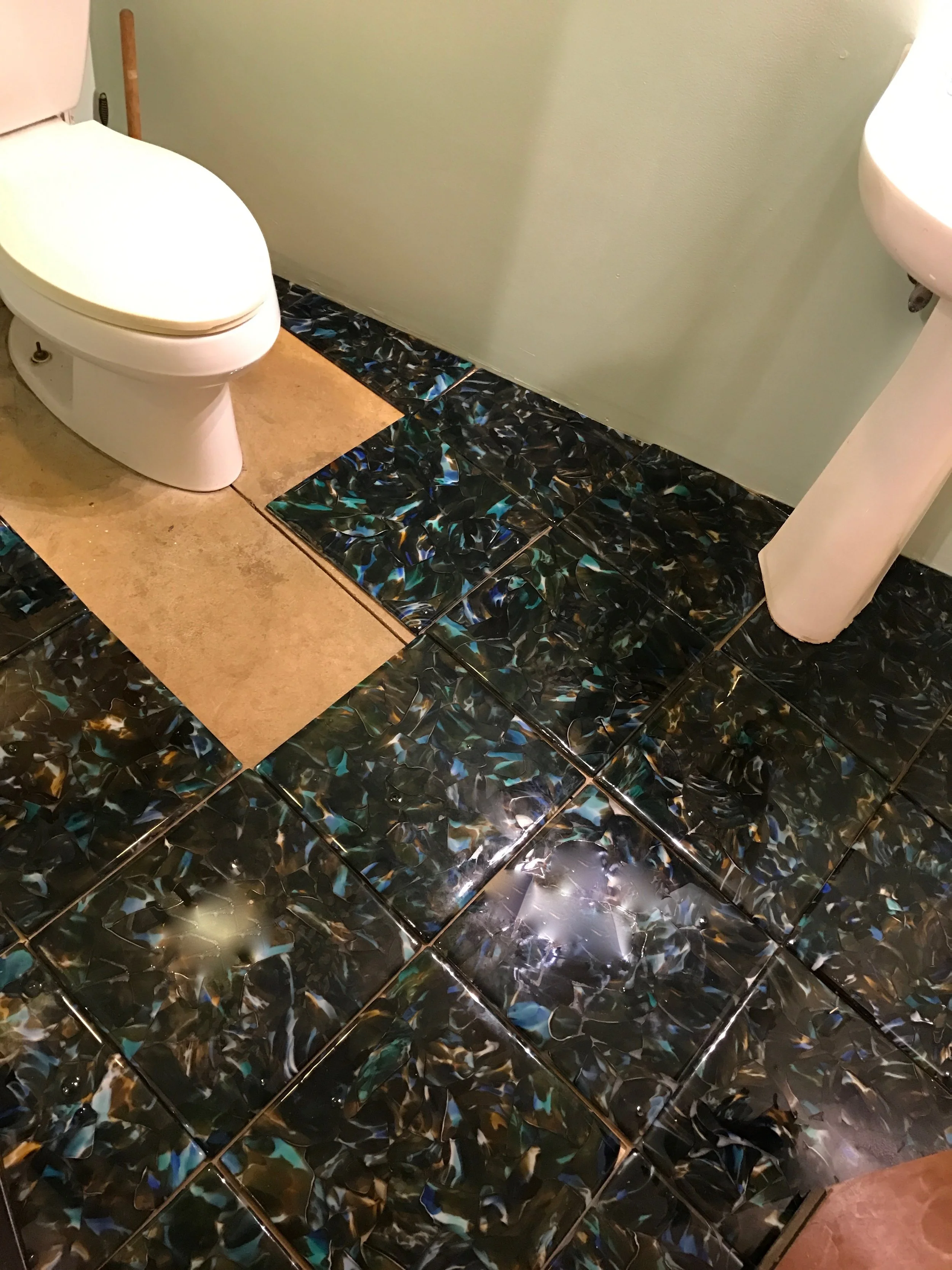 I made these tiles and Im calling them Pacifica 200 for their twice recycled from discarded glass. I trusted their beauty and fused them into 14" square tiles. My bathroom in the small showroom really needed some flooring. It will be great to experience how they stand up to normal use and clients will be able to see them installed. The bath is small enough so in case they are a bit slippery which we do not know at this point. fun stuff. I thought it would be great as Maui Open Studios is right around the corner and many people will be here to get their response. rick