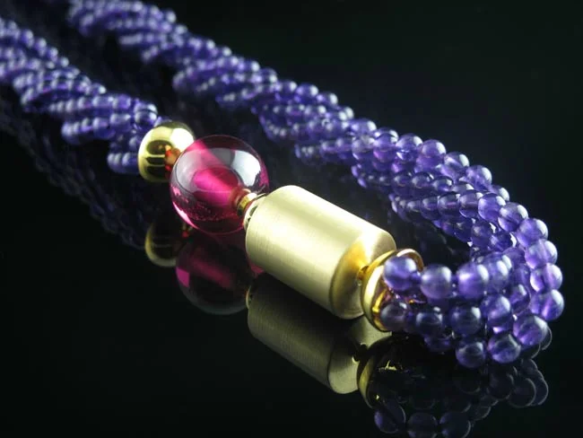 Ruby ball clasp and gold cylinder clasp on amethyst multistrand necklace.jpg