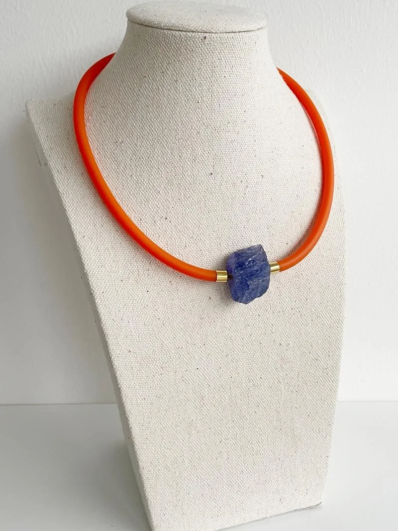 Orange-rubber-with-tanzanite-on-bust.jpg