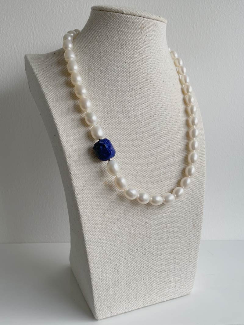 Oval cream pearl necklace with hammered lapis clasp
