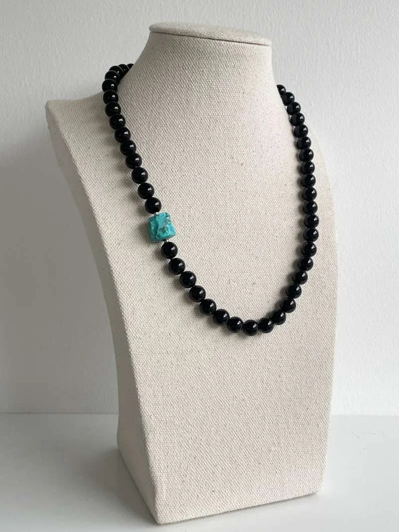 8mm black onyx bead necklace with small blue green interchangeable turquoise nugget feature clasp pictured on a linen bust