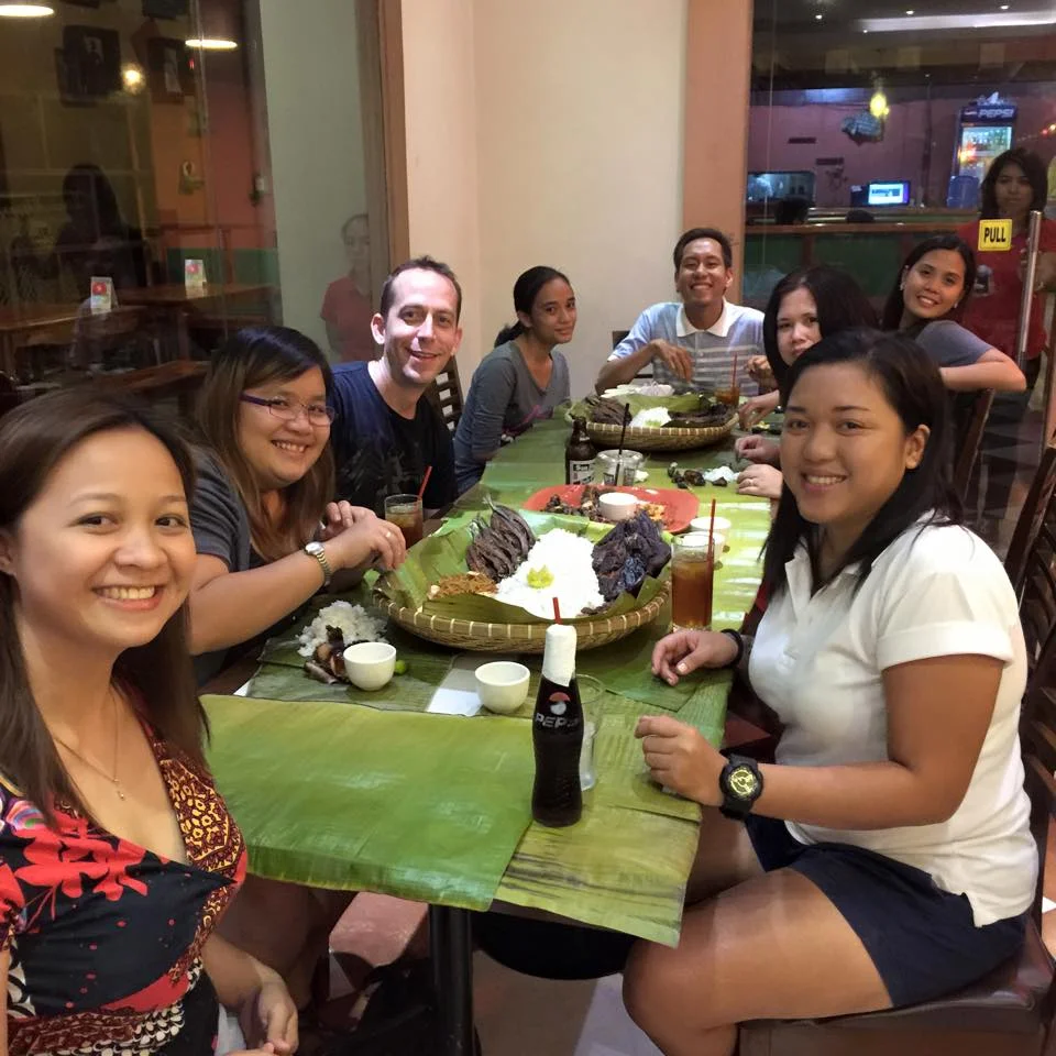 Team Rocket with Chris enjoying their boodle fight dinner at Captain Ribbers.