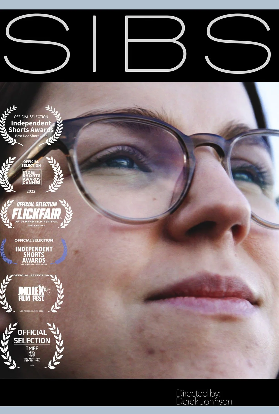 Close-up of a person's face with glasses, looking slightly upward, with multiple film festival award logos on the left side and the name of the director, Derek Johnson, on the bottom right.