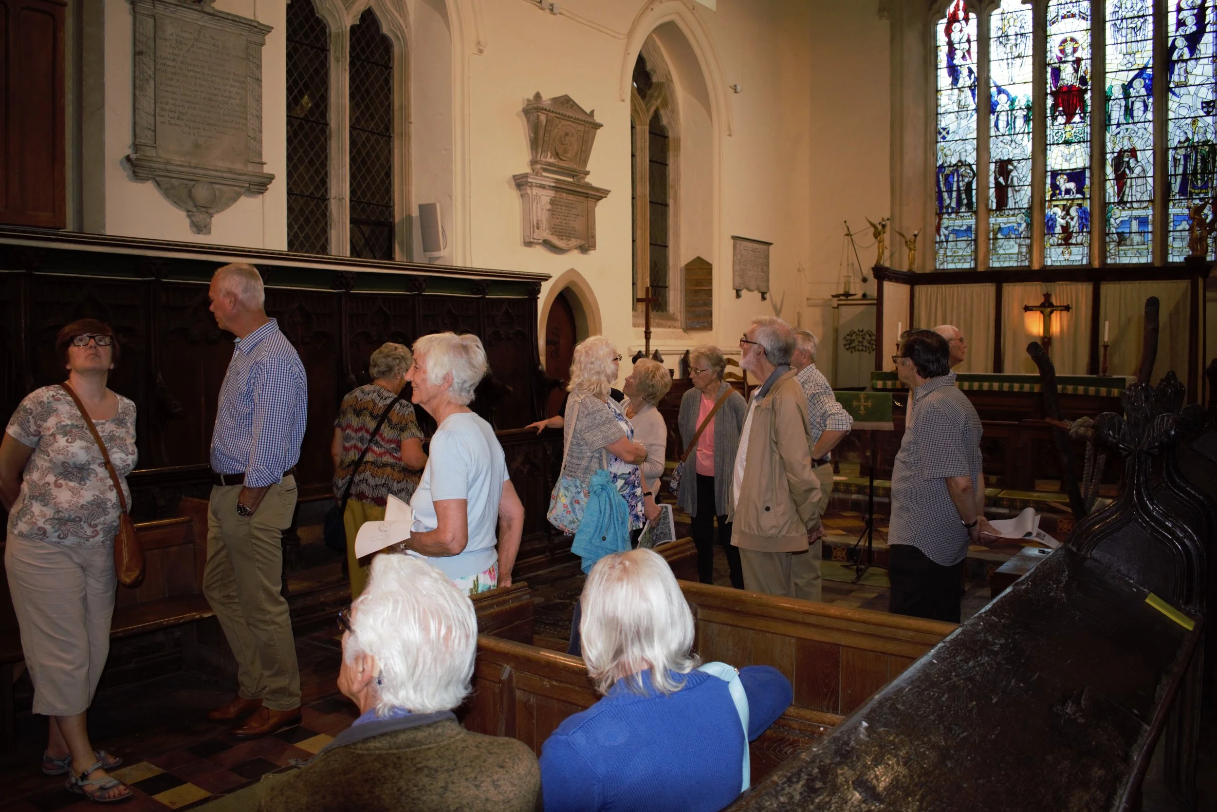 Sara from the Balsham Map Group with visitors inside Holy Trinity church, Balsham.