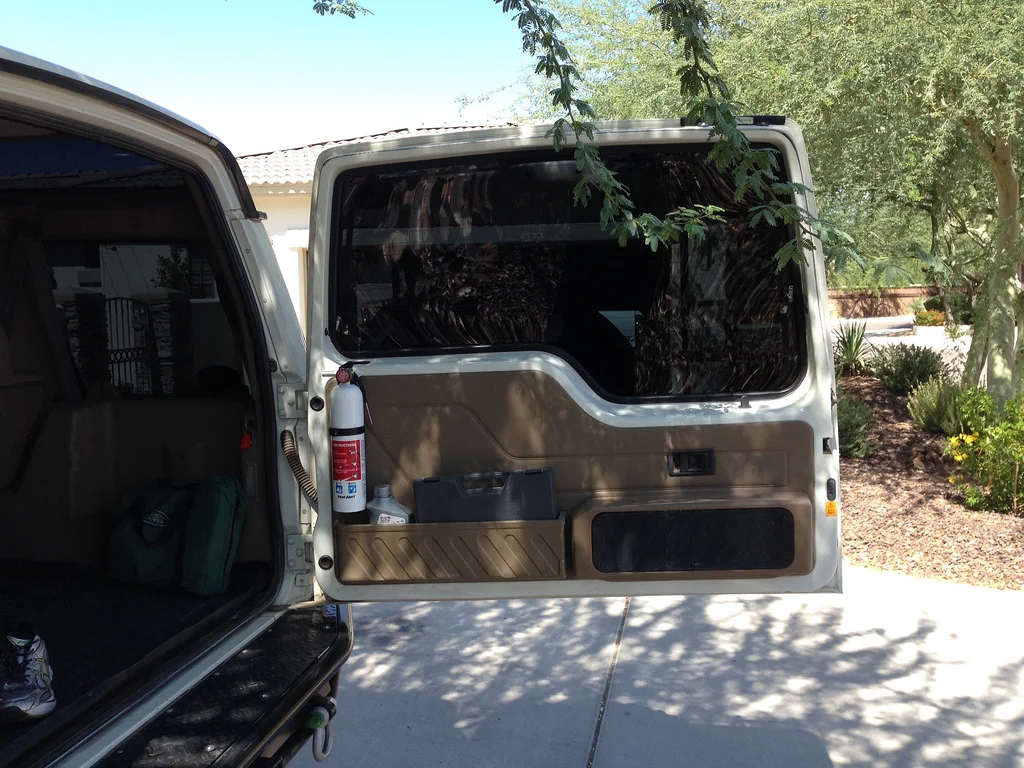 Since most vehicle fires ignite in the engine compartment, it makes sense to locate the extinguisher some distance away, but quickly accessible. The mount here ensures it can't be covered by luggage.