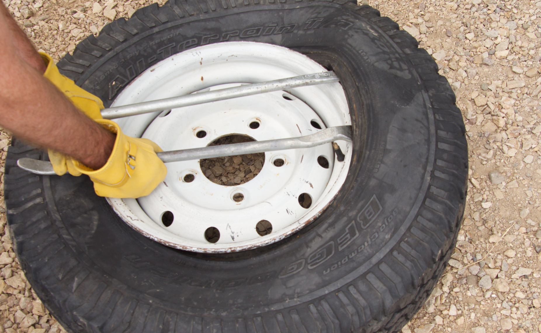 Using tire levers to pull the bead over the rim.