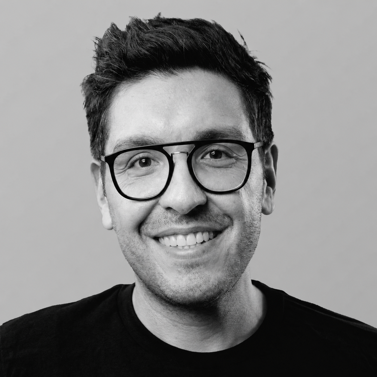 Black and white portrait of Bos Alvertos wearing glasses. Photo taken by Ben Vogel.