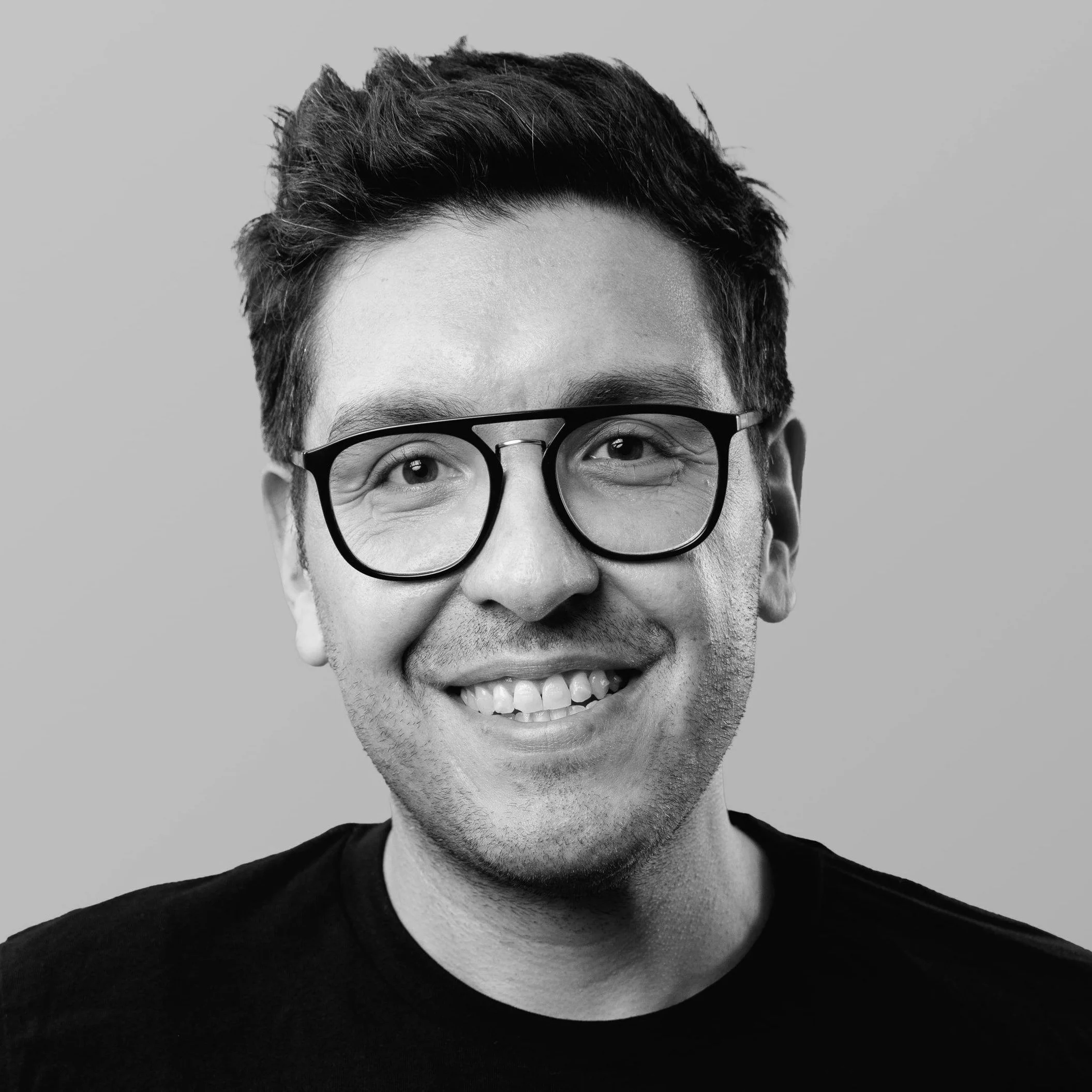 Black and white portrait of Bos Alvertos wearing glasses. Photo taken by Ben Vogel.