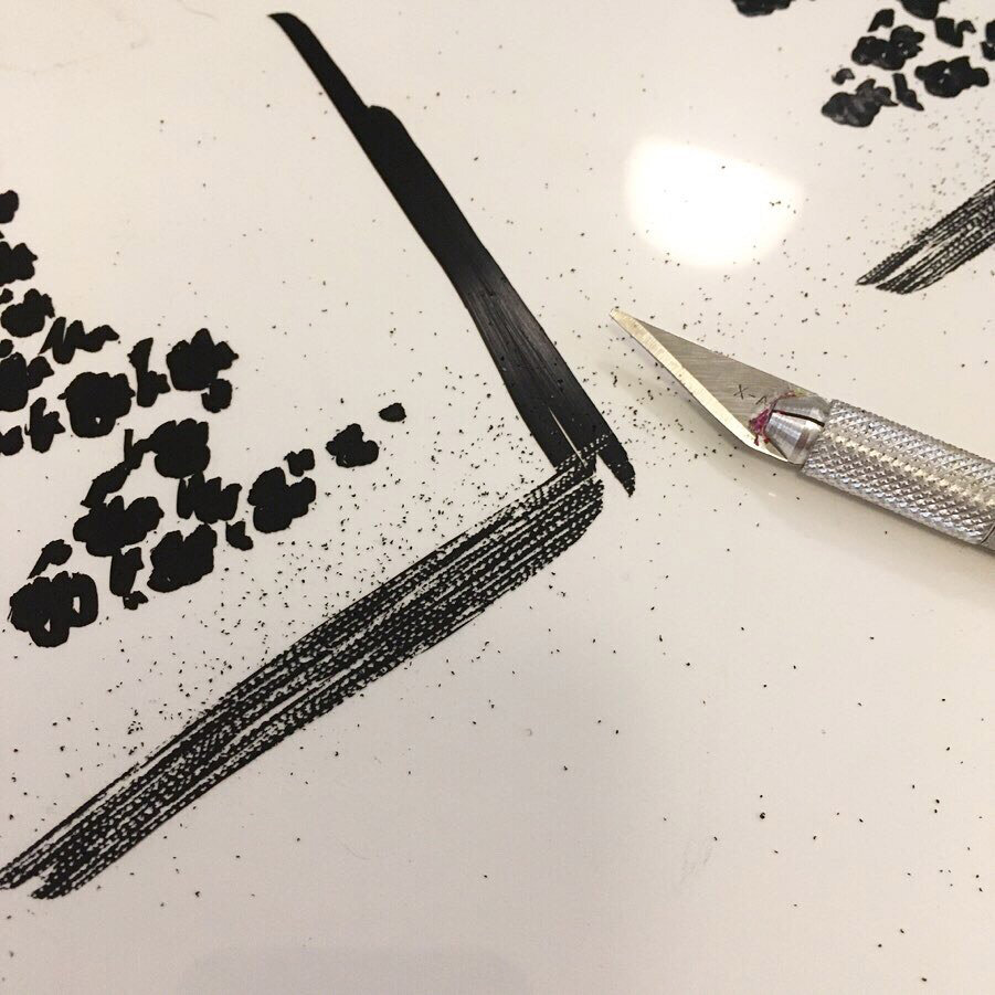 Applying and then scraping ink to create a wood grain effect