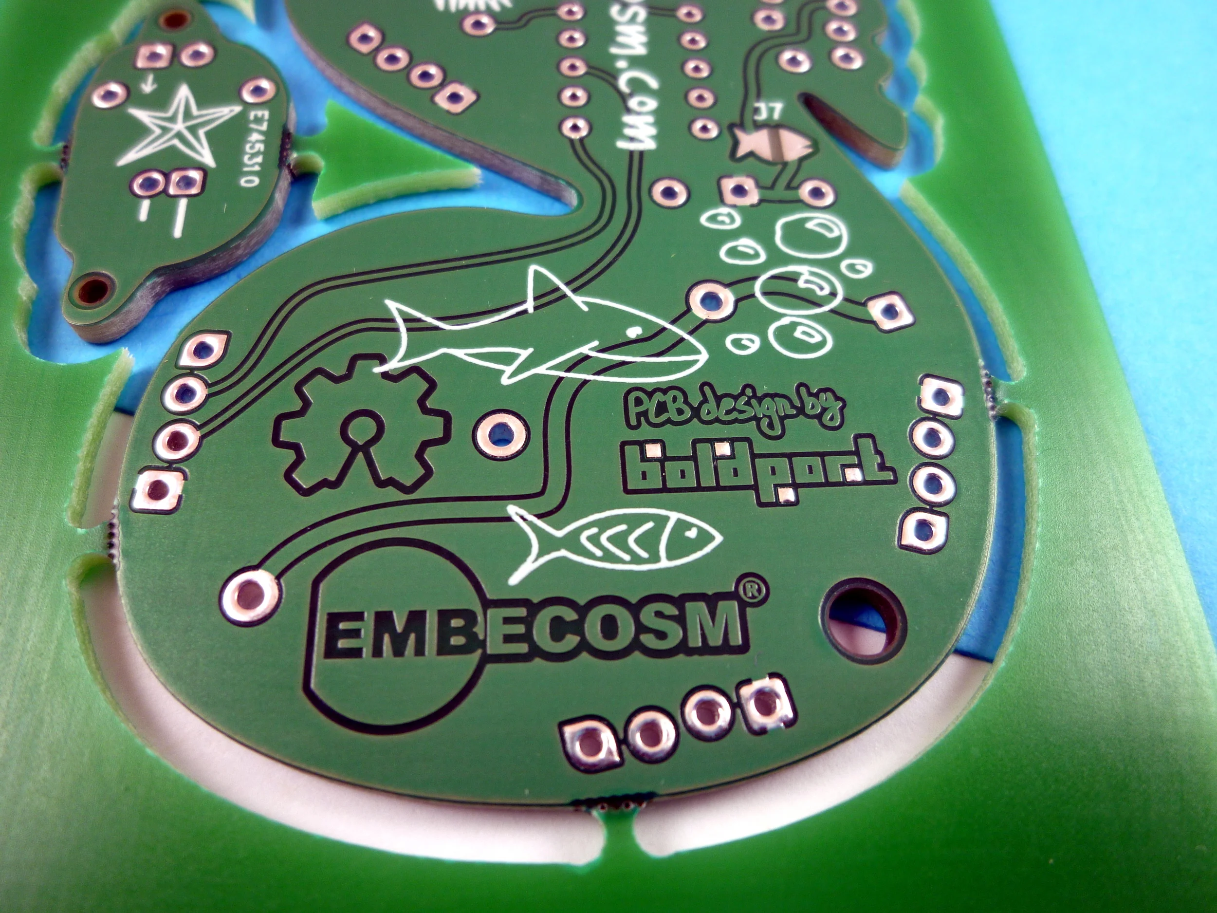 The solder-blob jumper is the on top right; it connects the programmer's 5V to the power plain, and assumes no battery is connected!