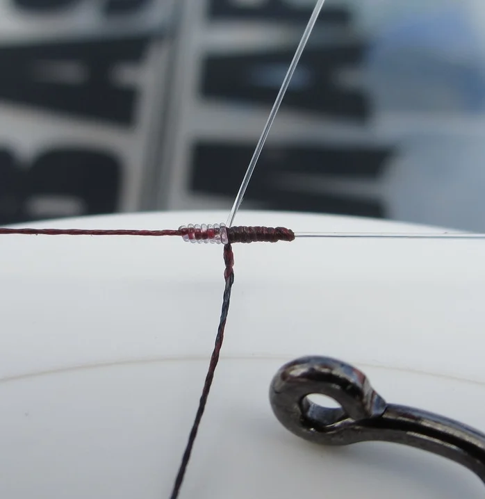 6 lb fluorocarbon tied to 15 lb braided line with a modified blood knot (7 wraps on the fluorocarbon, 11 wraps on the braid) Shown with a worm hook eyelet for size comparison. Truly a "micro" knot.