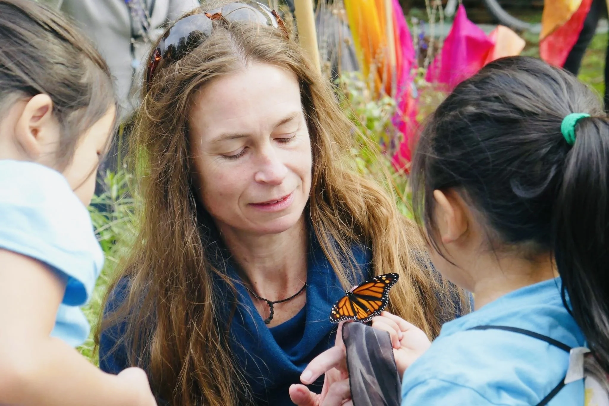Megan Hollingsworth with children and monarch butterfly during Lost Species Day pollinator procession, fall 2017