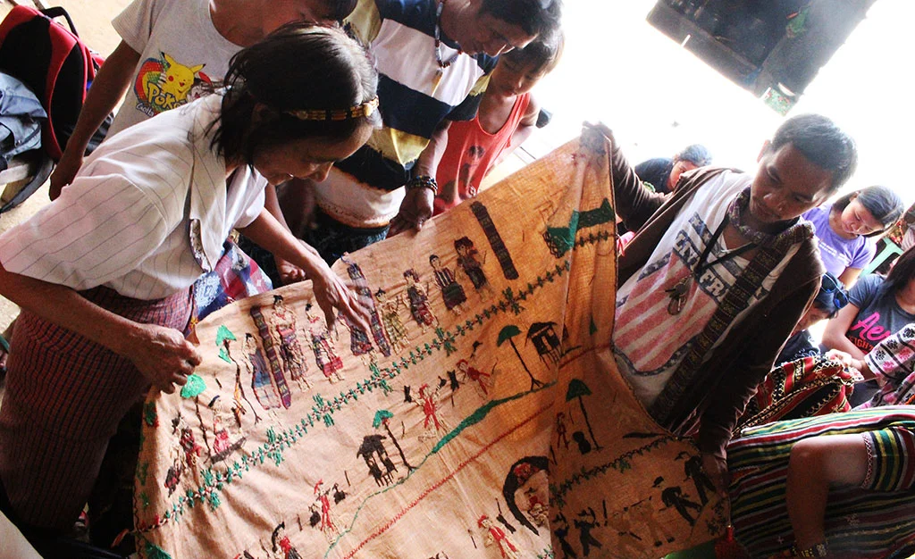 Norma Agaid narrating a tale woven in fabric about her ancestors, tribal wars, Gabriella Silang and other important events of their proud heritage.