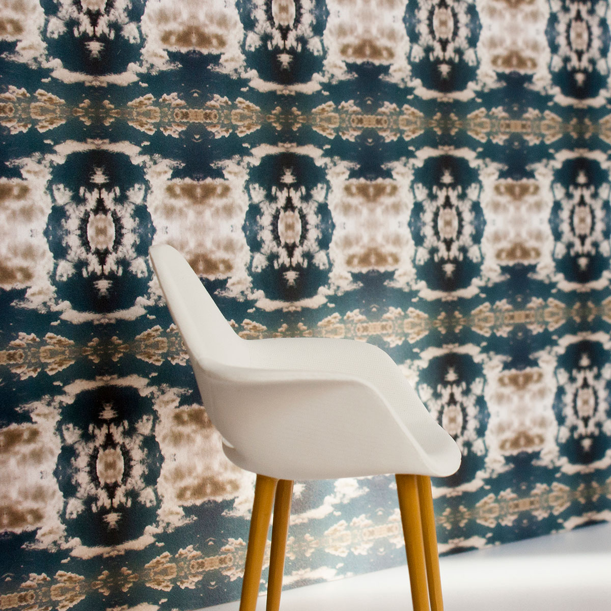 Cloud Rococo Wallpaper shown in Moody Blue, in situ with a white chair