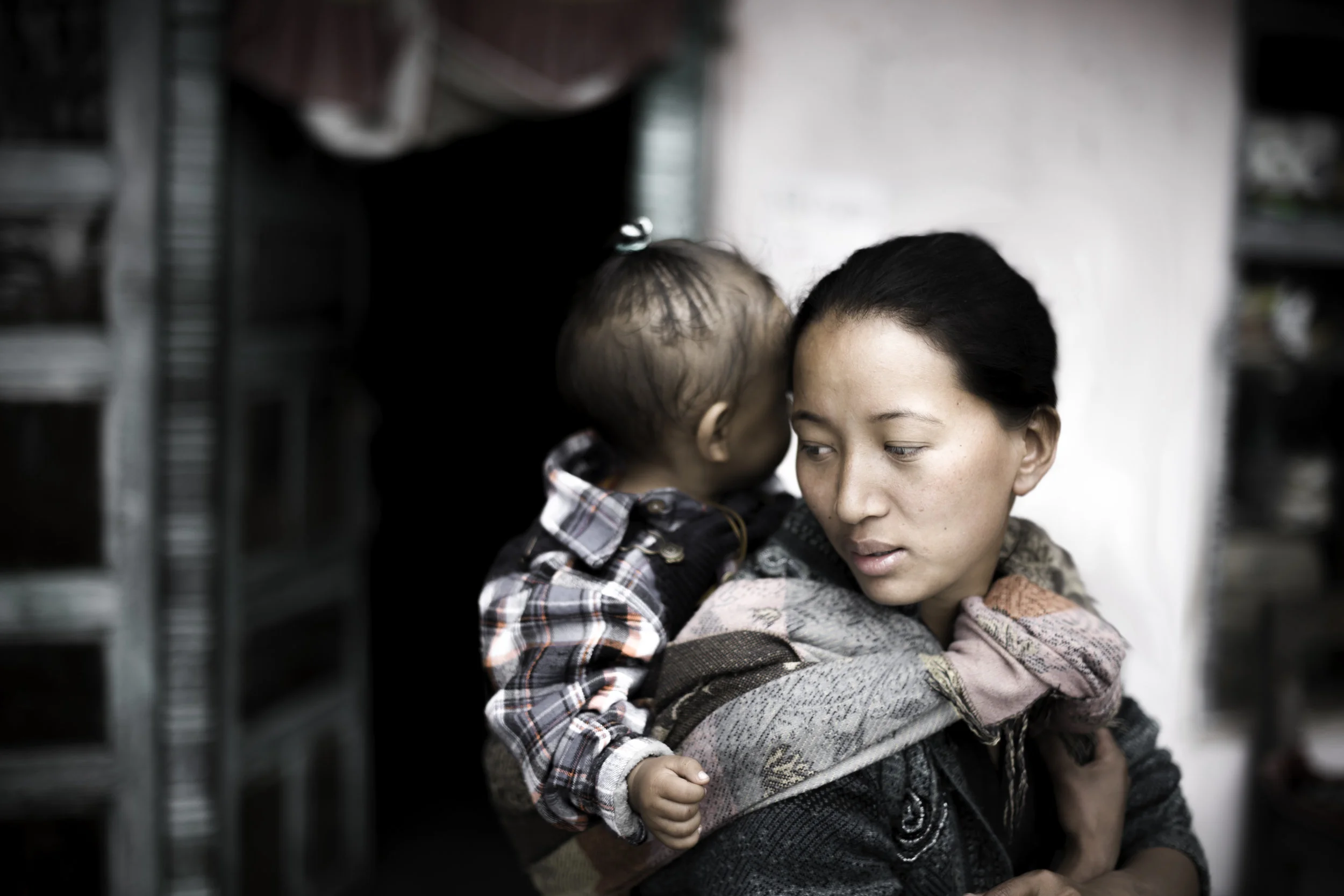   Tsiring is carrying her son through Khangjim. Children are a rare sight in Langtang these days.&nbsp;They are away in Kathmandu because all the schools in Langtang have been destroyed.  
