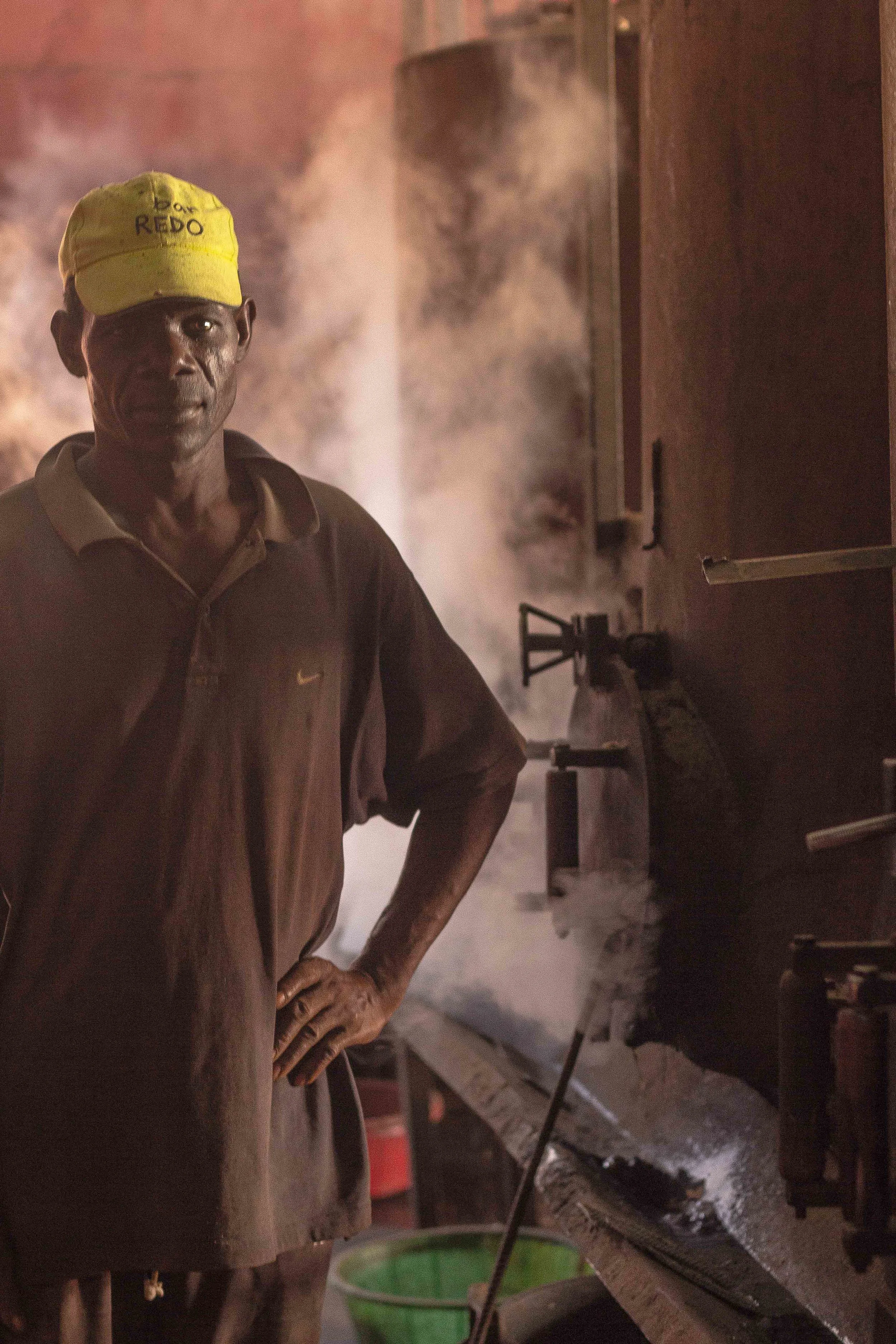 Anchilo district, Nampula province – A worker in the cooking section of the Condor Nuts factory waits while the cashew nuts are cooked in the boilers | Um trabalhador na secção de cozedura na fábrica da Condor Nuts espera as castanhas