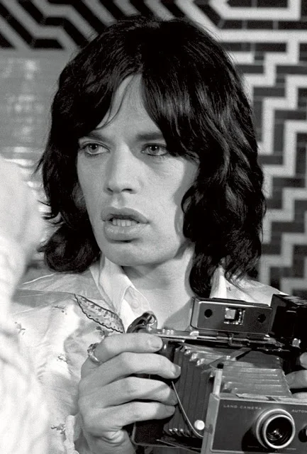 Mick Jagger with a Polaroid. Image by Baron Wolman.