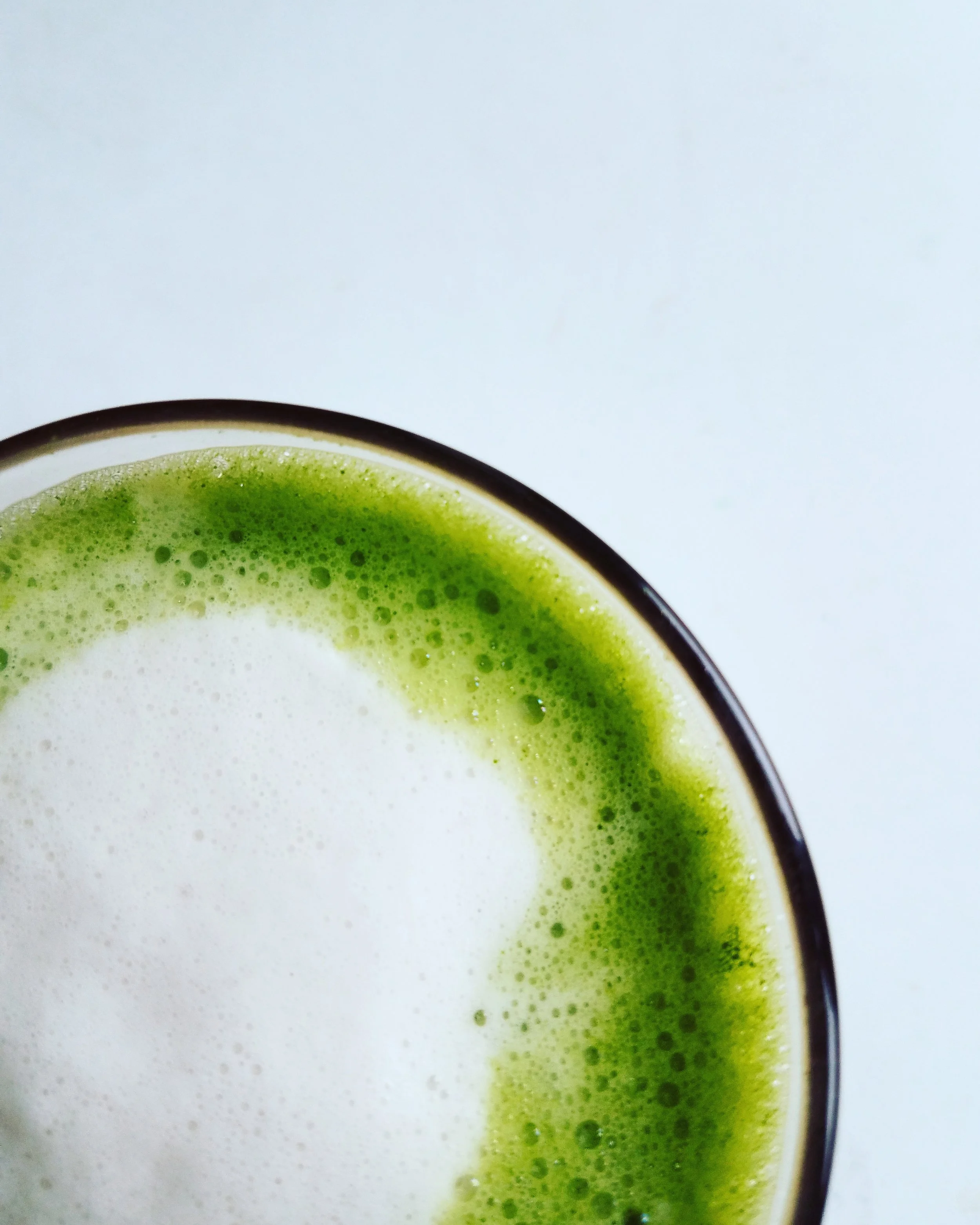 Matcha is delicious. REALLY delicious. It is creamy and velvety and DELICIOUS. Not only that, it is AMAZING for you. It is said to boost your metabolism, enhance weight loss, detoxify your body and prevent premature aging. Research is even being carried out into its anti-cancer benefits . Oh, and it’s delicious. Go get a cup RIGHT NOW and read on about this magical powder. Here is my little love letter to Matcha. What is Matcha? Matcha comes from the same plant that all true teas come from; Camellia Sinensis. The leaves from this plant can be made into green tea (unfermented - simply steamed and dried), into oolong (partially fermented) and black tea (fully fermented). Matcha is a true green tea, but growth style, harvest and production are different. This plant does have different varieties, some of which produce higher grade Matcha, the best coming from Samidori, Okumidori and Yabukita. Why is Matcha so bright? Three weeks before harvest the tea plants are covered with bamboo mats or tarp, depriving them of sunlight. This increases the chlorophyll content and turns the leaves a dark green which gives Matcha it’s color. The leaves are then harvested, steamed and air-dried. They are then sorted for grade, destemmed and deveined. It is at this point that the leaves become “tencha”. Once the tencha is ground it becomes Matcha. What grade of Matcha should I choose? If you want to reap the full health benefits of Matcha, look for ceremonial grade or hyper-premium. These best grades are ground on a stone mill. This process is slow, keeping the temperatures low to preserve high nutrient levels. It also produces a molecule with a specific shape which influences the taste and feel of the Matcha. Lower grade Matcha, such as culinary-grade, is ground by machines and can taste bitter when made into a tea. When buying Matcha, look for the uber-vibrant green color provided by the overproduction of chlorophyll. If it is duller (like moss), don’t expect best quality. What does it taste like? Matcha has an umami taste (a Japanese term for the fifth scientific taste meaning “rounded, rich, savory”). It tastes quite different from other teas. I was never a big fan of steeped green tea, but I love Matcha. Why should I try Matcha? Matcha has a different effect on your body than coffee. The caffeine from Matcha delivers a calm energy rather than an urgent, jittery restlessness. Matcha has long been used by Buddhist monks to help their daily meditation due to the combination of caffeine (which fights off drowsiness) and L-theanine (which sharpens focus and concentration). L-theanine, present in Matcha at around 5 times the levels when compared to a regular cup of green tea, is an amino acid which is reported to have a calming, relaxing effect, reducing anxiety. Whilst espresso delivers an instant effect, the l-theanine in Matcha is released slowly, keeping your energy levels up longer. What else can Matcha do for me? Matcha is rich in epigallocatechin gallate (EGCG, also known as catechin). Because you are taking the whole leaf, instead of just steeping and throwing them away, one cup of Matcha can deliver the health benefits equivalent to 10 - 20 cups of regular green tea. EGCG is said to prevent cell degeneration and premature aging. It can boost your metabolism, assisting your body’s ability to utilize energy. How to make a great cup · Source the best quality possible, making sure it is from a Japanese farm. · Place a small amount, around 1 teaspoon, Matcha into a cup or bowl. · The water you add should be hot but not boiling - between 150 and 170 degrees. If you don’t have a thermometer, after boiling the kettle, remove the lid and let it stand for a minute or two before using. · Add a small amount (a few tablespoons) of this water to the cup, whisking into a soft paste, adding more as you whisk to reach the consistency you desire. The ratio of Matcha to water is up to you - the more Matcha the thicker and frothier the tea. You can use the traditional chasen (a bamboo whisk) or an electric milk frother wand but if you don't have either, begin by using a teaspoon and mix in the same way as you would cocoa powder, ie small amounts of liquid until a paste is formed, adding a little more at a time. For a teaspoon of Matcha I would suggest a cup around the size of a macchiato (longer than an espresso, shorter than a (true!) cappuccino). · If you like, replace some of the water with a small amount of foamed milk. I use ⅔ water ⅓ unsweetened almond milk . · If you really need, add a drop or two of (best quality!) stevia. I did this in the beginning but now prefer the taste without. · Matcha is also delicious served iced. If you haven’t tried Matcha yet, please don’t let your first experience be from any old cafe. Do it yourself or search out somewhere that serves the best quality. I have experienced some terrible versions out there, often low quality, overly sweetened or just drowned in a store-bought milk which takes over the taste. Of course, this isn’t true of all cafes, there are a few who serve a truly good version. If you make it for yourself at home, try it the traditional way, with only water, and then if you like, add a little steamed (non-dairy is best) milk and (best quality) sweetener only if you need it.