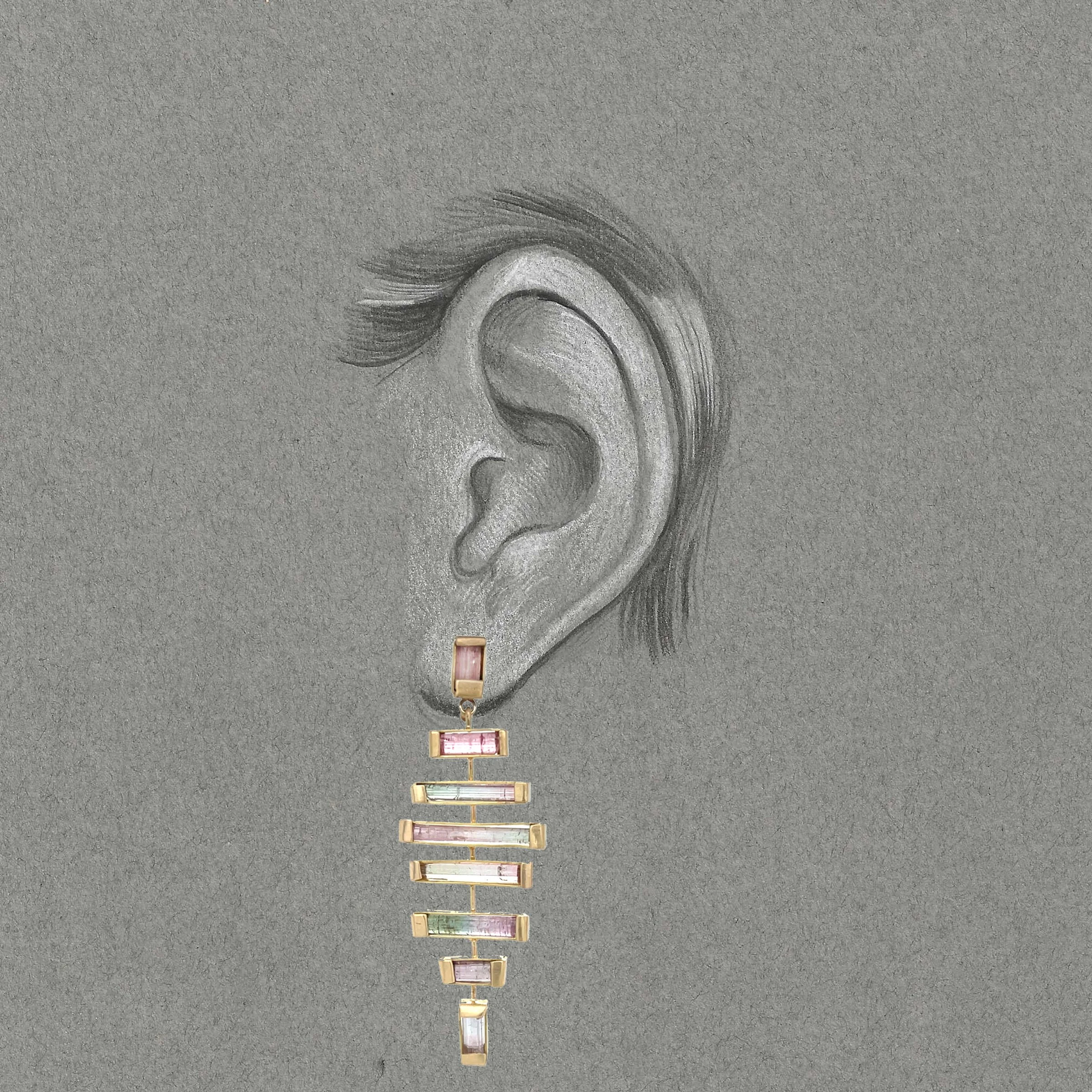 Black and white drawing of an ear with long pink and green tourmaline gemstones set in gold.
