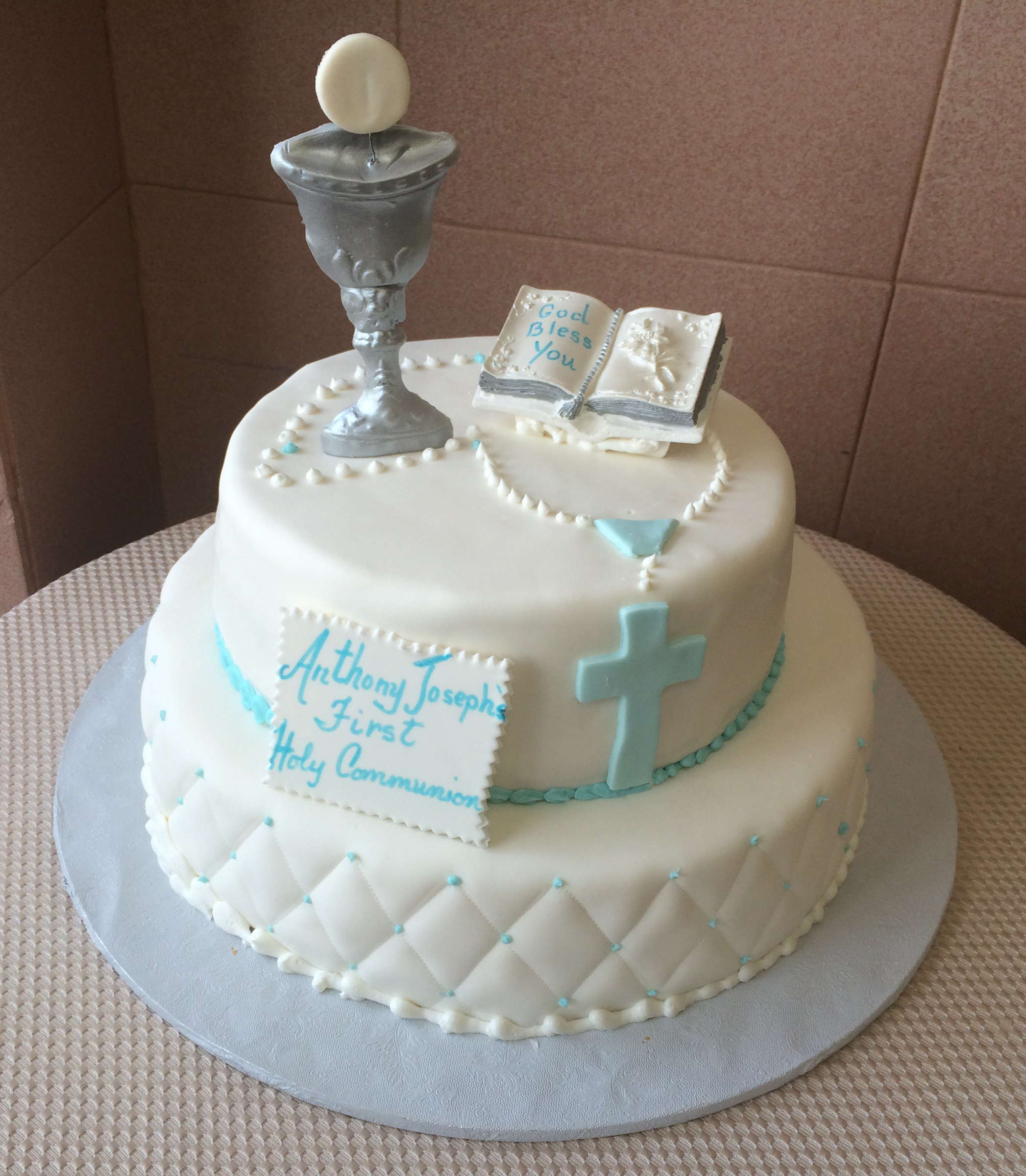 White Rolled Fondant quilted w blue, blue ribbon, blue rosary beads, standing silver chalice & ceramic keepsake bible.JPG