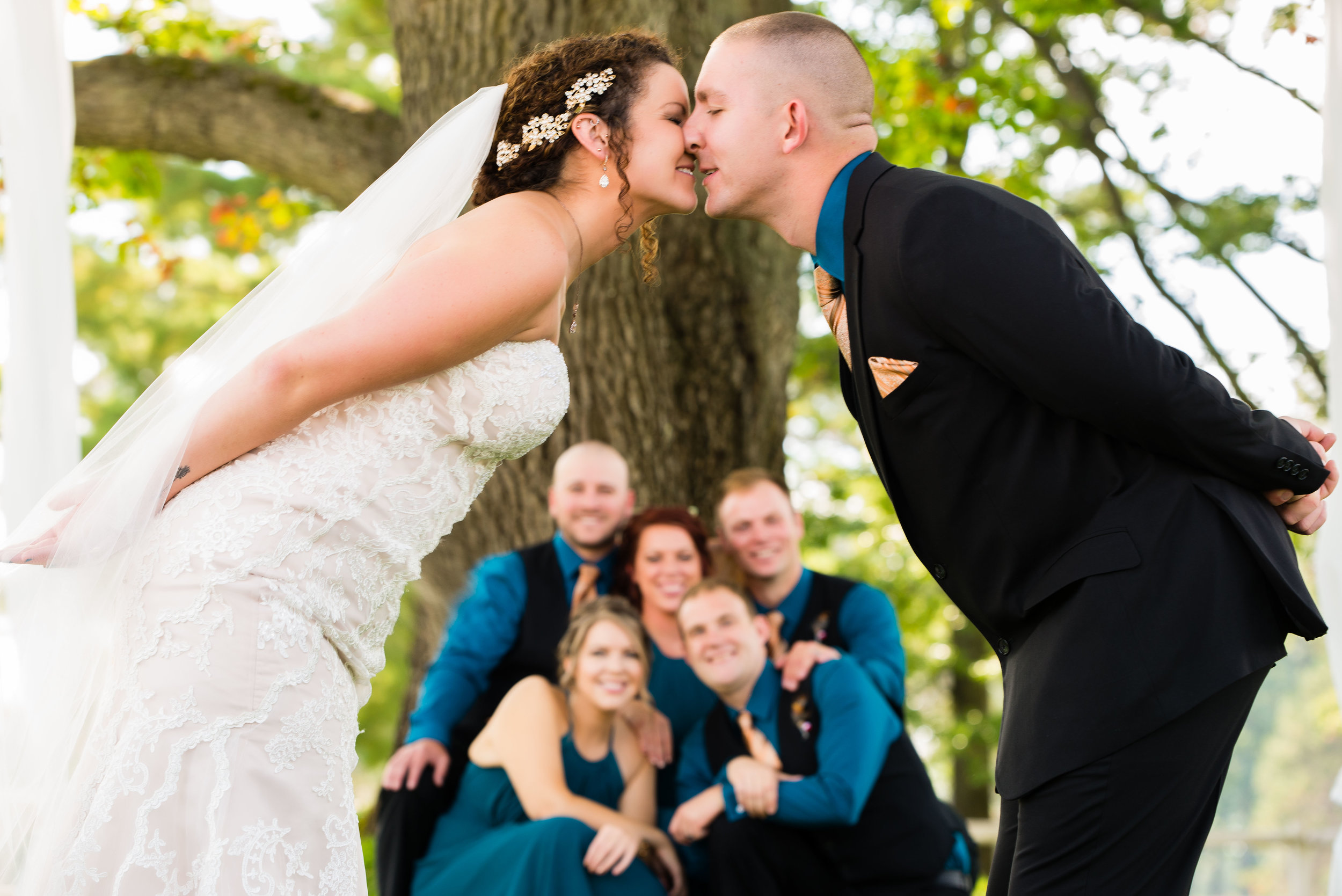 Newlyweds Kiss with Bridal Party in Background