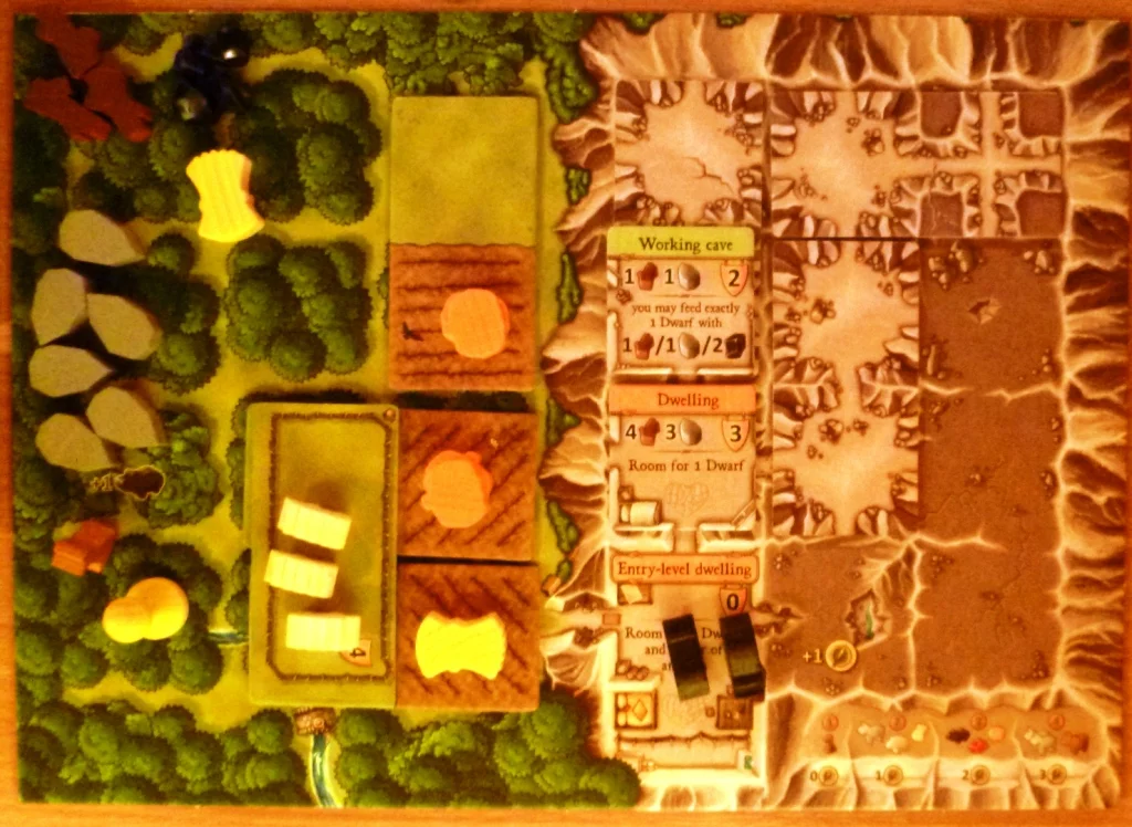 Player board in early stages of game, with some sheep in a pasture, 2 pigs in a cave and wheat and vegetables planted in fields