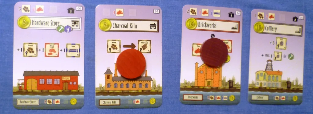 Four of the building cards, Red has converted wood into charcoal, when the charcoal kiln was built it cost 1 clay to build.