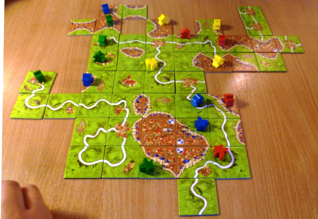 Carcassonne - Blue on the road feature looking to on the right while yellow has a stake in several cities at the top