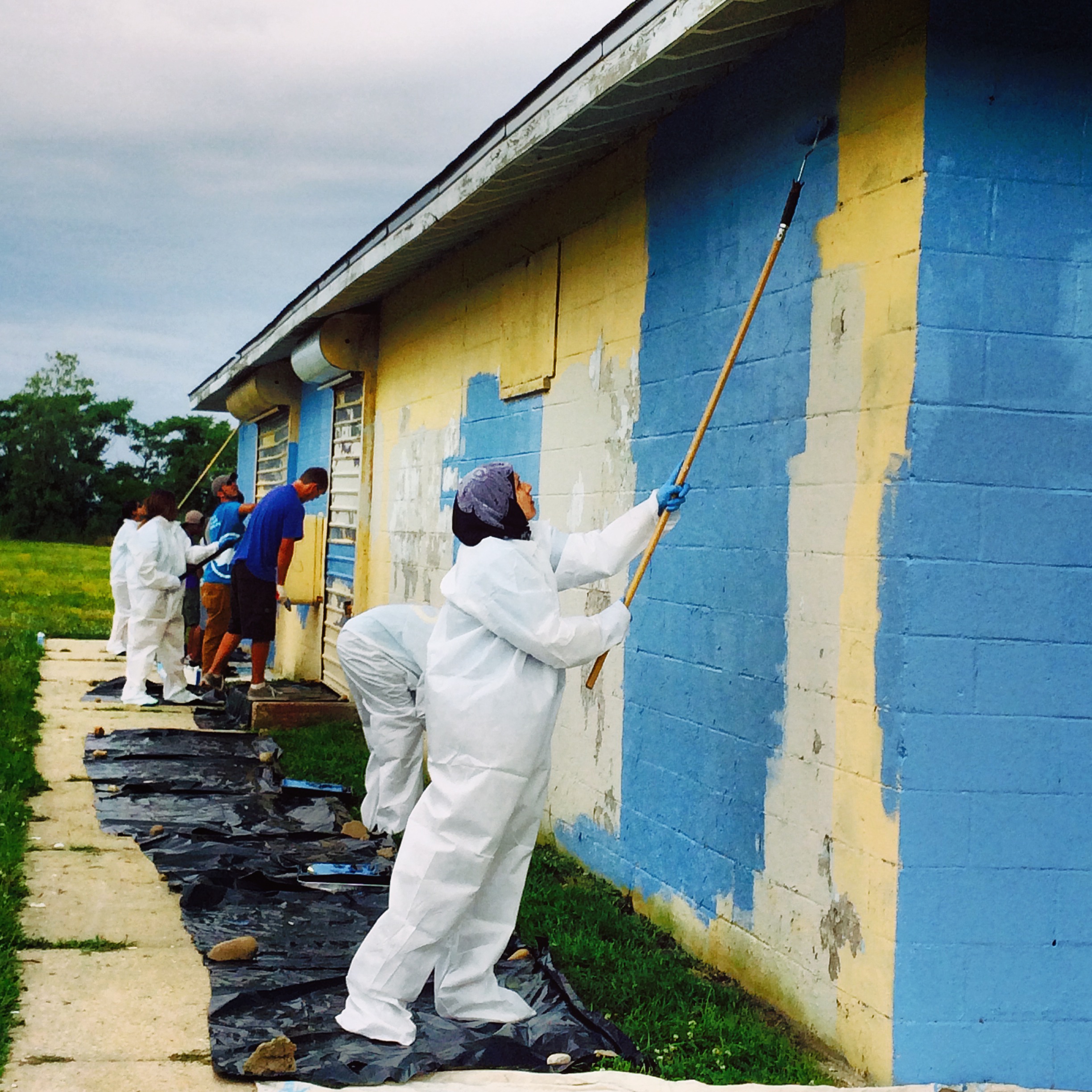  Volunteers spruce up a building with a fresh coat of paint at American Ballfields Park. 