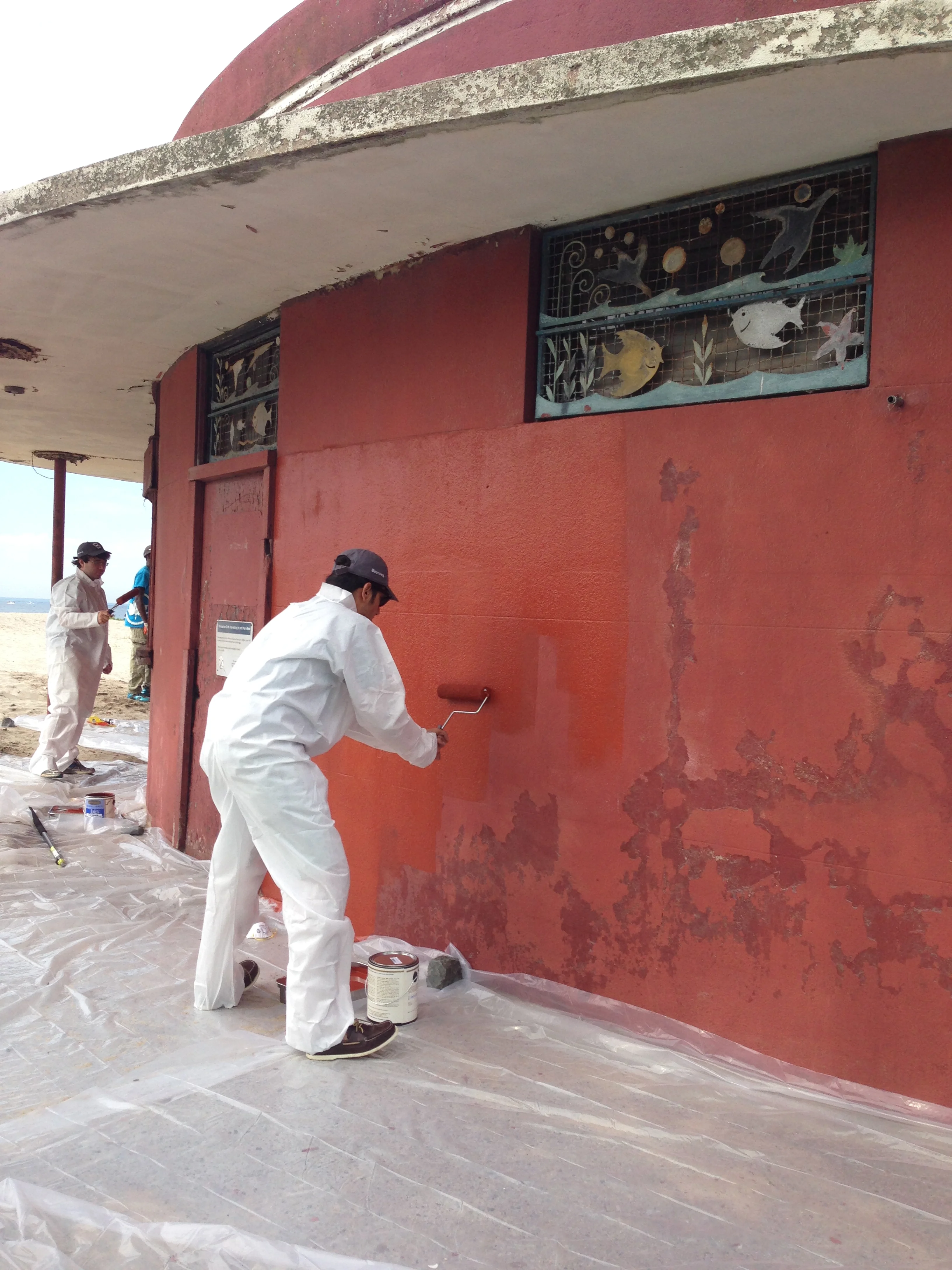 Volunteers coat the Plumb Beach Roundhouse with fresh paint.