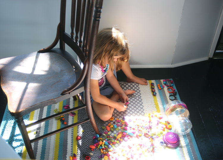 Harper sitting in the sun kissed window making her jewelery for the day.