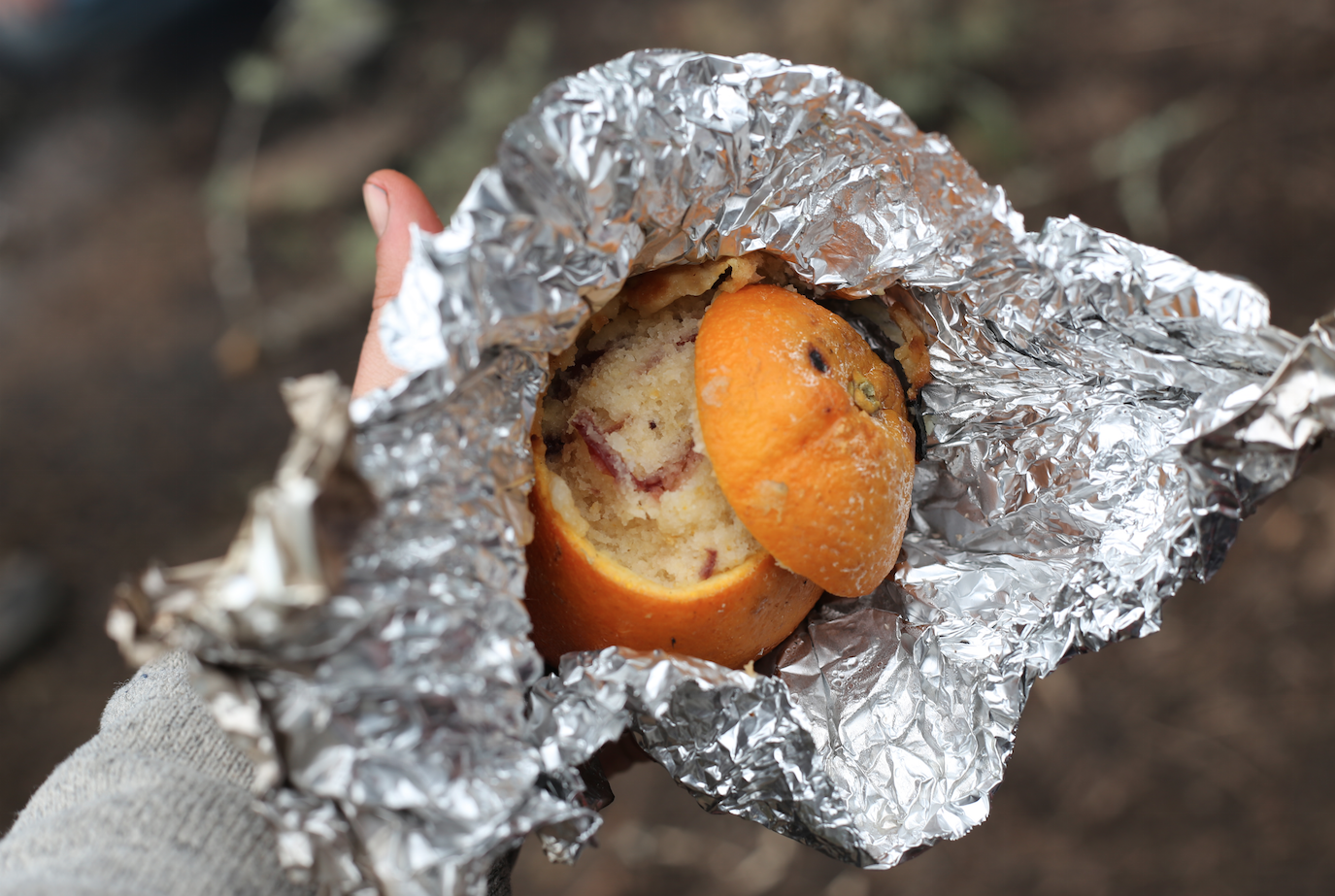 cranberry lemon campfire muffins inside of an orange peel