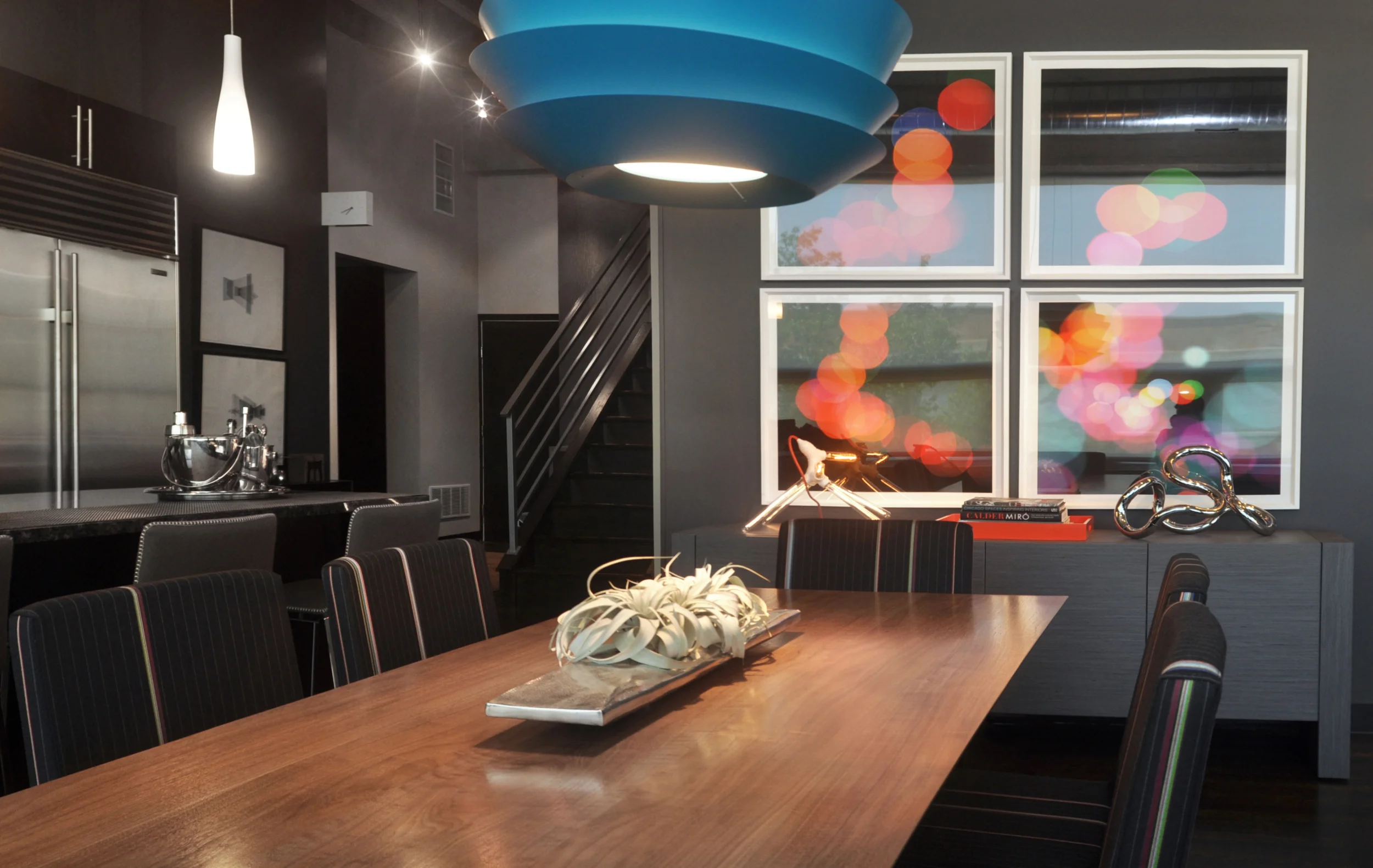 Creating this modern interpretation of a bachelor pad was pure fun! By first developing a neutral backdrop, we were able to imbue the space with an incredible amount of style through pops of color, custom designed furnishings, and an inspired art collection; including a floor-to-ceiling wall graphic installation by Chicago artist Connie Noyes. Through the aforementioned elements this space was fundamentally transformed from a boring industrial box to an environment built for inspiration and entertaining. What we did: When this particular client approached us, he had already had false-starts with two other interior designers. Through our client-driven process, we finalized space plans, selected thoughtful furnishings, designed custom pieces, and curated a full art collection of both local and nationally-recognized artists. 