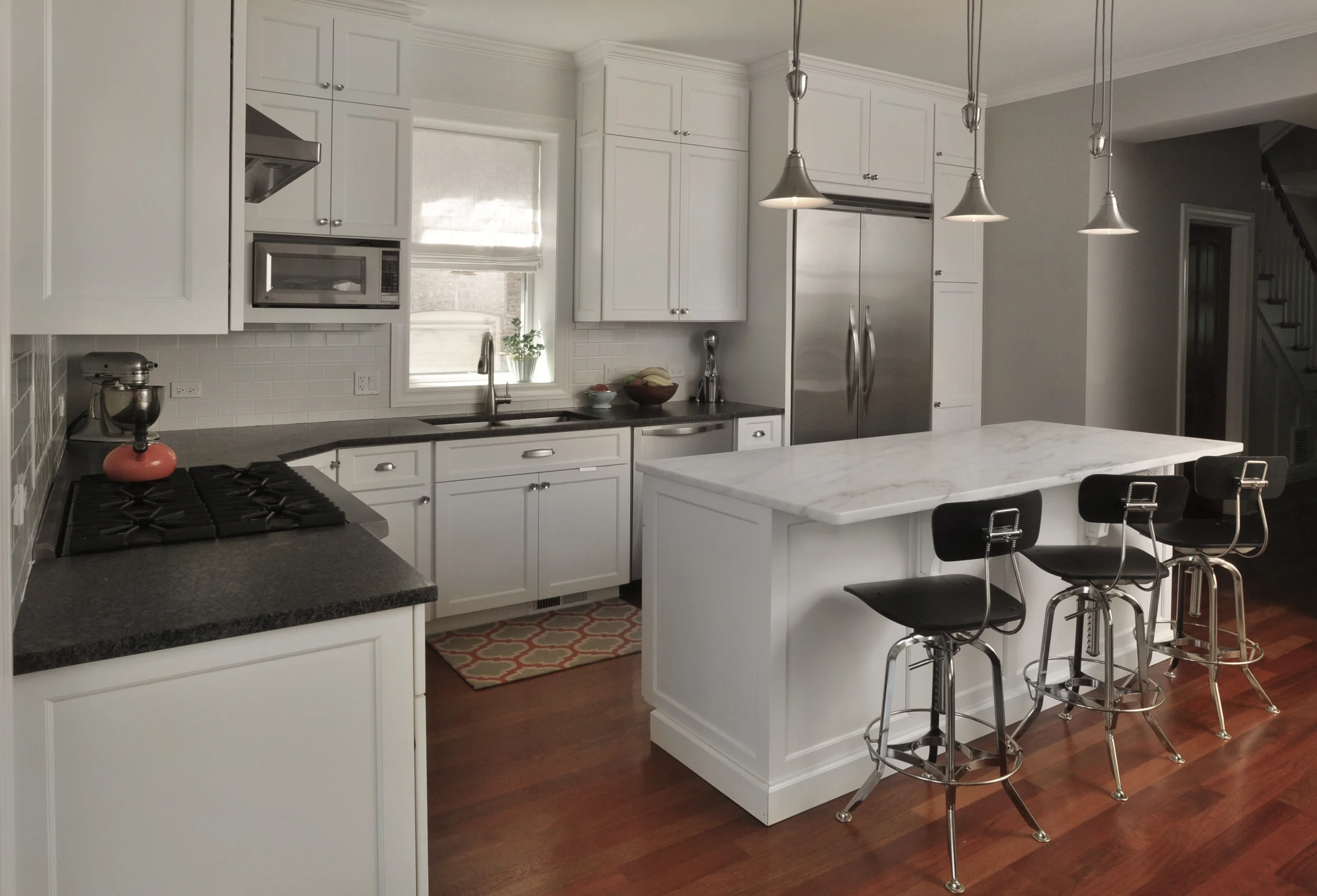 In order to meet the multi-functional needs of this active family we redesigned the flow of the main living area of their home inclusive of moving the kitchen from one side of the house to the other. Through thoughtful space planning we were able to fundamentally change the feel of the main living space. A once disconnected and dark kitchen is now a prominent and purpose-filled feature in the house thus allowing the family to be fully engaged with the heart of their home. What we did: NMI was hired to redesign the kitchen and living areas of this home. Through our initial planning exercises we realized that the optimal solution for this family included completely moving the kitchen. We produced all necessary construction documents, structural plan reviews, and construction management. In addition, we implemented space plans throughout the first floor and redesigned the basement living area. 
