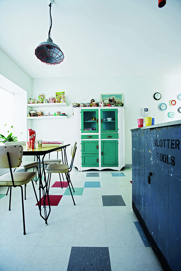 Randomly positioned shades of floor tiles pick up on the colours of the units and furniture and break up the plainness of other white surfaces.