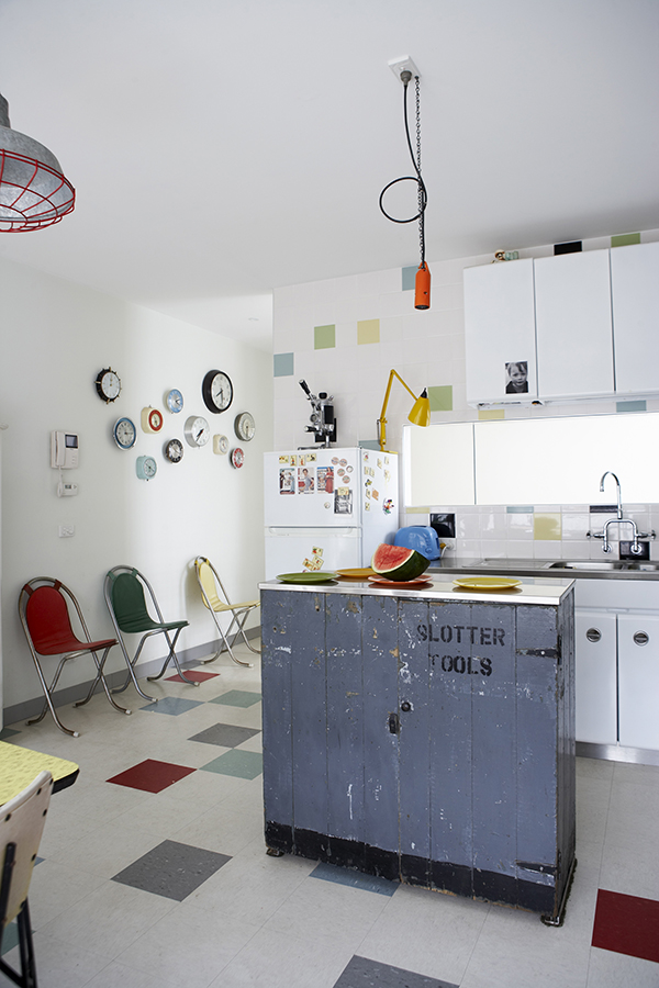 In the post-war spirit of βMake do and mendβ an old tool cabinet has been recycled as a store cupboard and a vintage caged industrial light hangs from the ceiling nearby.