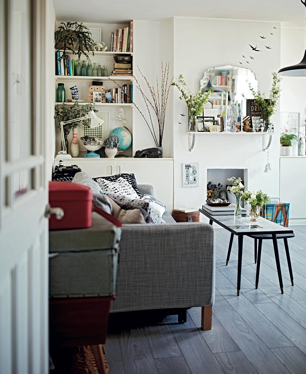 Despite its small size, a huge amount of personality has been packed into the living room. Shelves flank the chimney breast and another was added above the non-working fireplace to provide more surface space for this globe-trotting couple’s collections, largely picked up on their travels. Potted plants and vases of branches bring the room to life and last longer than cut flowers.